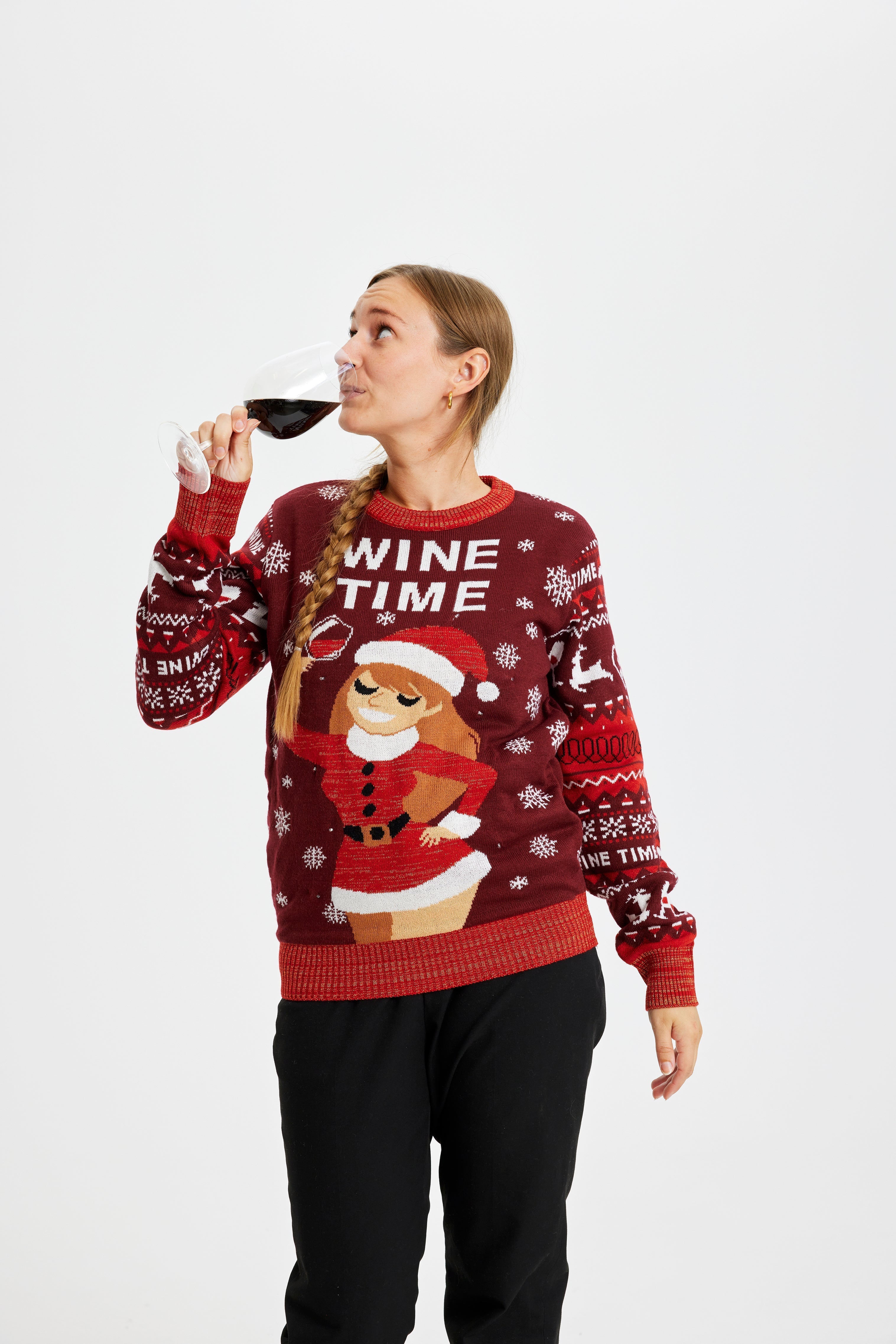 Una coppia con un bicchiere di vino che indossa un maglione rosso natalizio con la scritta